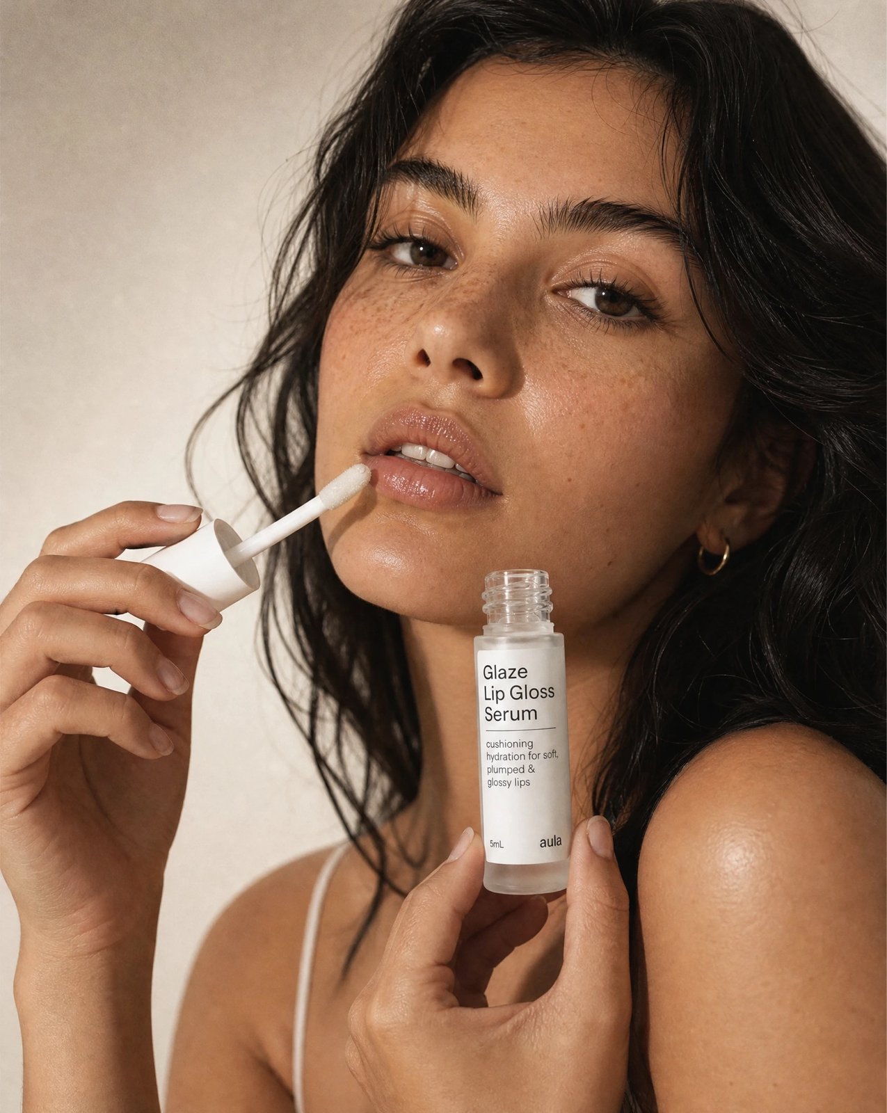 Model applying Glaze Lip Gloss Serum